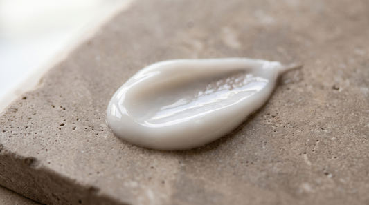 Swirl of lightweight gel-cream moisturizer on warm greige stone